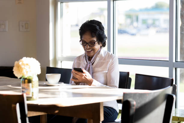 istock Confident senior woman uses smartphone in cafe 1176649480