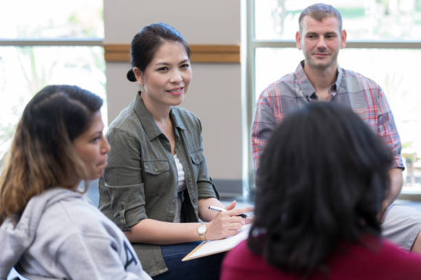 istock Attentive counselor facilitates group therapy session 1176649653