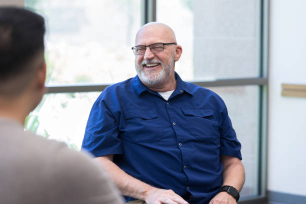 istock Cheerful man smiles during support group meeting 1176649720