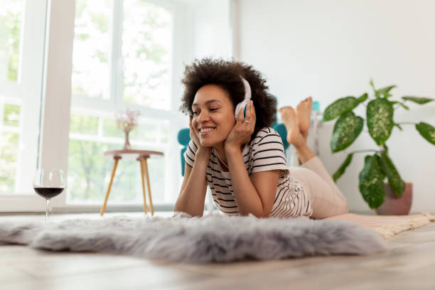 mujer escuchando la música y relajándose en casa - attractive female only young women music living room fotografías e imágenes de stock