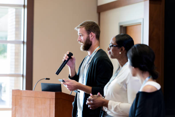 istock Young man addresses crowd during conference 1176650852