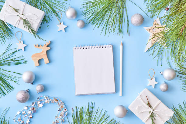 istock Mockup white notebook with pine branches and christmas decorations on a blue background 1176651352