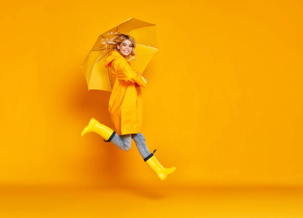 giovane ragazza felice emotivo ridendo con ombrello su sfondo giallo colorato - 11874 foto e immagini stock