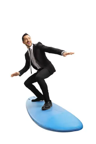 Full length shot of a young businessman standing on a surfing board isolated on white background