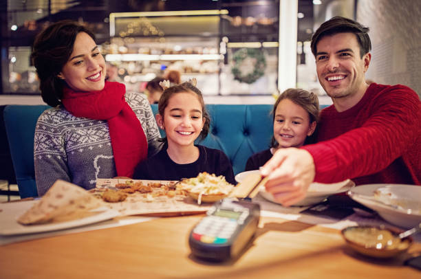 istock Husband is paying using contactless credit card in the restaurant at Christmas 1176658527