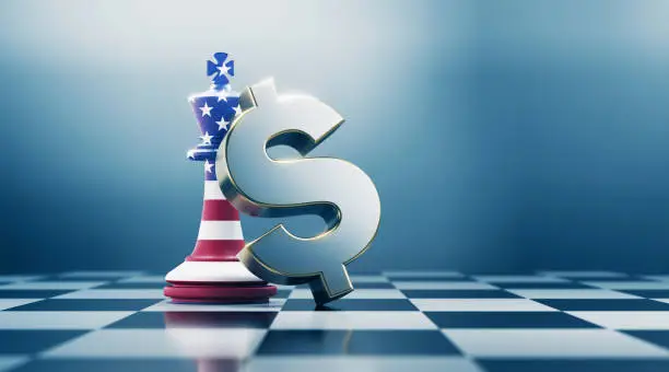Single king chess piece and metallic American dollar sign are standing on black and white chessboard. King chess piece is textured with American flag. Horizontal composition with selective focus and copy space. Great use for American dollar concepts.