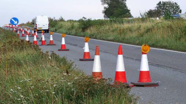 istock roadworks cone flashing on UK motorway at evening with traffic passing 1176670012