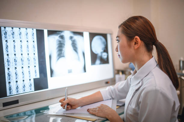 istock Young Female Japanese Nurse Studying X-Rays and Making Notes 1176676436