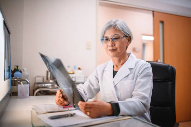 istock Focused Senior Female Japanese Doctor Studying X-Rays 1176676443