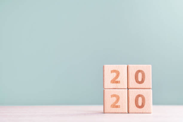istock Abstract 2020 design concept - geometric wood blocks cubes on wooden table and low saturation gray green background. 1176676721