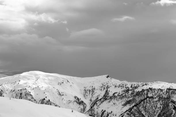 istock Sunlight snowy mountains and cloudy gray sky in winter 1176677721