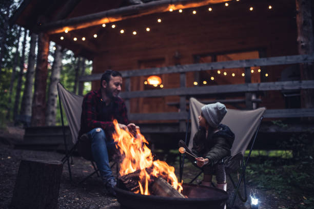 Father and daughter  having fun by the campfire Father and daughter  having fun by the campfire at their cabin in the woods candy house stock pictures, royalty-free photos & images