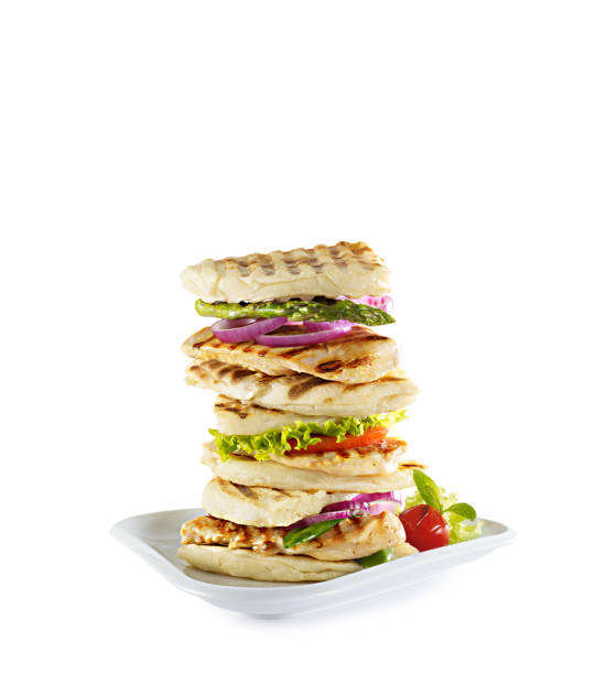 Grilled and pressed toast with turkish sausage, cheese, tomato and lettuce served on white plate