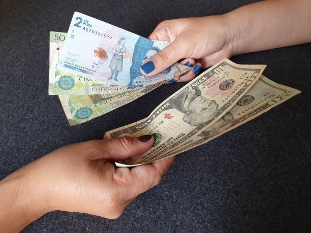 women hands exchanging C8 banknotes and American dollar money background for business, economics and finance issues colombian peso stock pictures, royalty-free photos & images