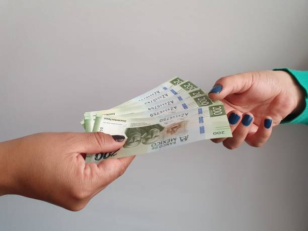 mujeres manos pagando y recibiendo dinero mexicano - mexican currency fotografías e imágenes de stock