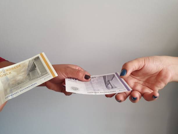 デンマークのお金を支払い、受け取る女性の手 - danish currency ストックフォトと画像
