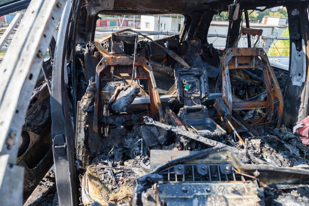 istock A burnt car after a fire or an accident in a parking lot covered with rust and black coal with scattered spare parts around. Robbery, arson, terrorism. 1176692126