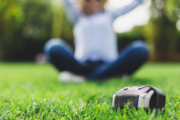 Portable speaker next to a sitting girl