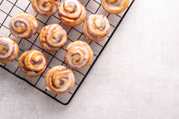Homemade baked cinnamon rolls on cooling on cooling rack stock photo
