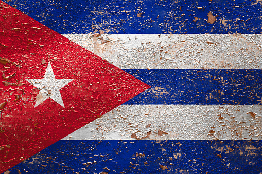 National flag of Cuba on old peeling wall background.The concept of national pride and symbol of the country.