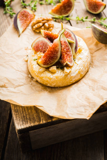 istock Baked camembert cheese with figs, walnuts, honey and thyme on the rustc background 1176698576