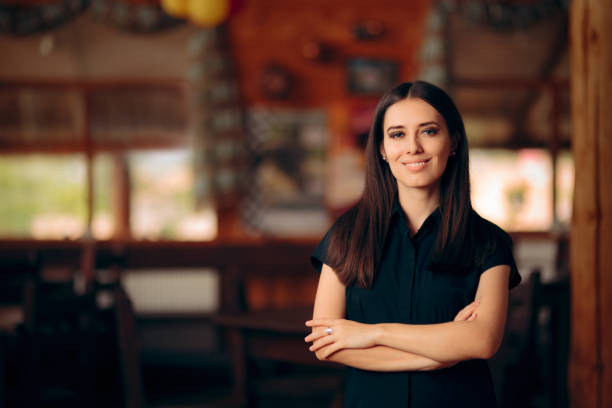 gerente de pie en un restaurante dando la bienvenida a los clientes - party host fotografías e imágenes de stock