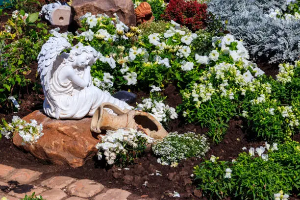 Photo of White marble statue of angel in ornamental garden