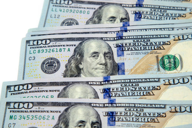 istock A bundle of hundred dollar bills laid out like a fan. On a white background. Background of dollar bills. American Dollars Cash Money. Hundred Bucks. Benjamin Franklin's portrait 1176708257