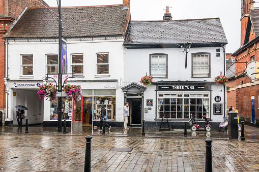 High Wycombe, Engalnd - August 14th 2019: Man stood outside a pub smoking on a rainy day. The law forbids smoking inside pubs.