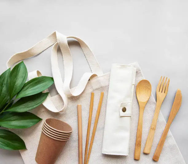 Cotton bag and recycled tableware top view. Zero waste, eco friendly, plastic free background. Flat lay.