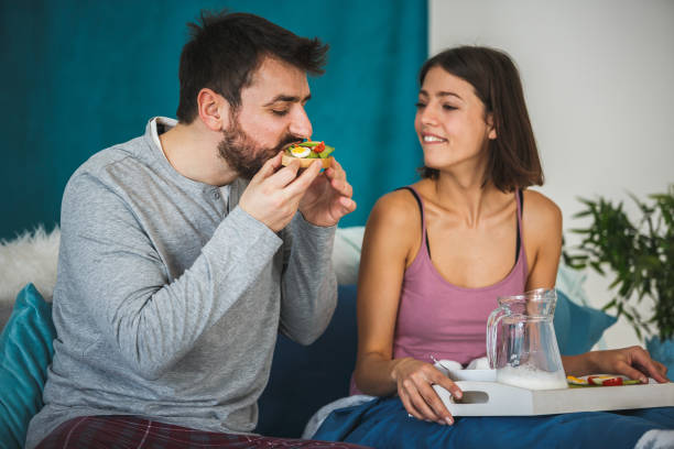 istock Young man enjoying breakfast in bed with his wife 1176710077
