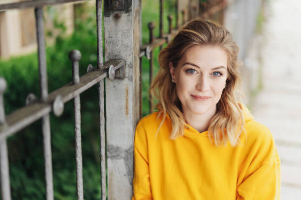 istock Pretty young blond woman leaning on a fence 1176710246
