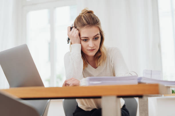 istock Young woman sitting studying at home 1176711285