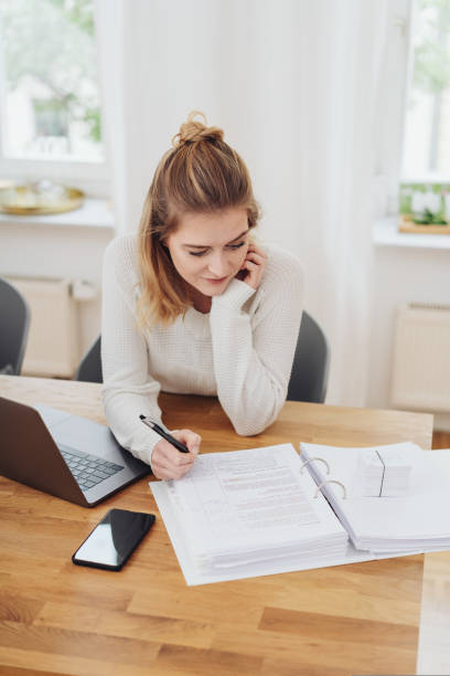 istock Young businesswoman working on office paperwork 1176712713