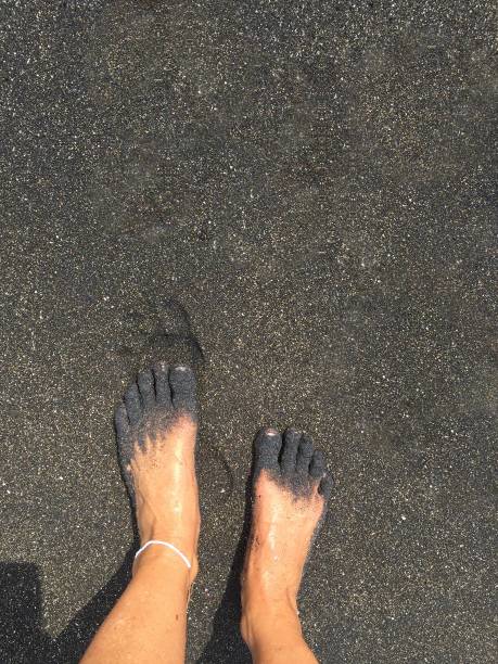 Feet in black sand stock photo