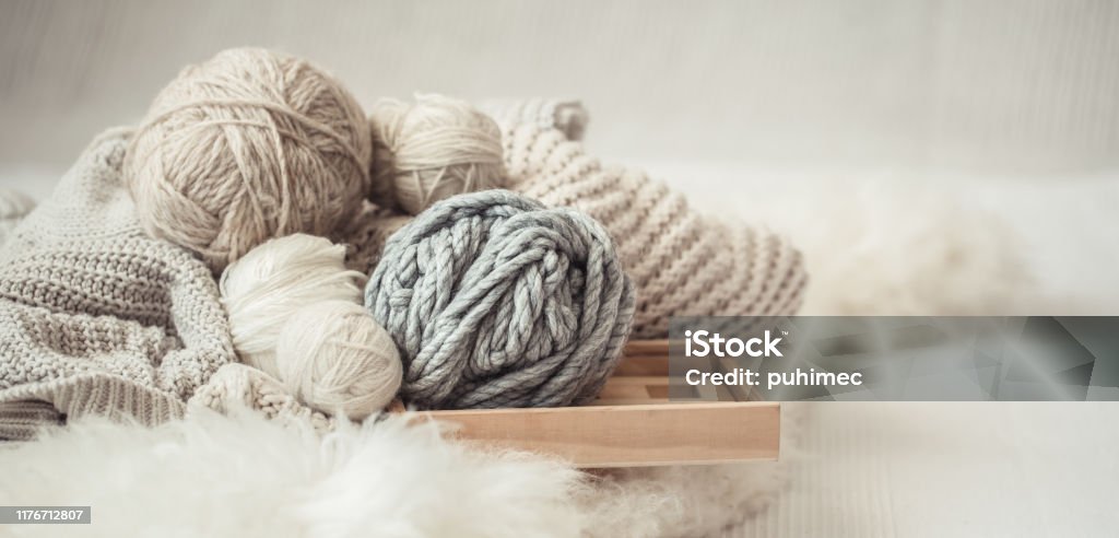 cozy background Wallpaper with the yarn for knitting. cozy background Wallpaper with a variety of threads for knitting. Close up. Ball Of Wool Stock Photo