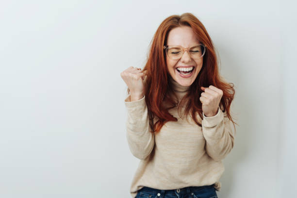 istock Exuberant young woman cheering and punching air 1176713754