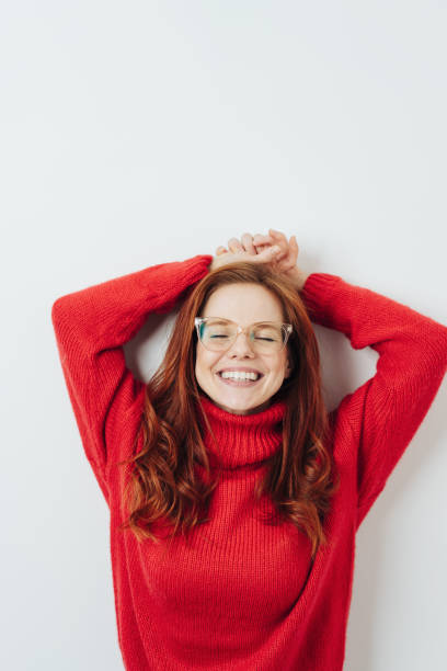 donna rilassata con gli occhi chiusi e le braccia alzate - vertical caucasian glasses red hair foto e immagini stock