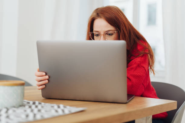 istock Young woman wearing glasses working on a laptop 1176714800