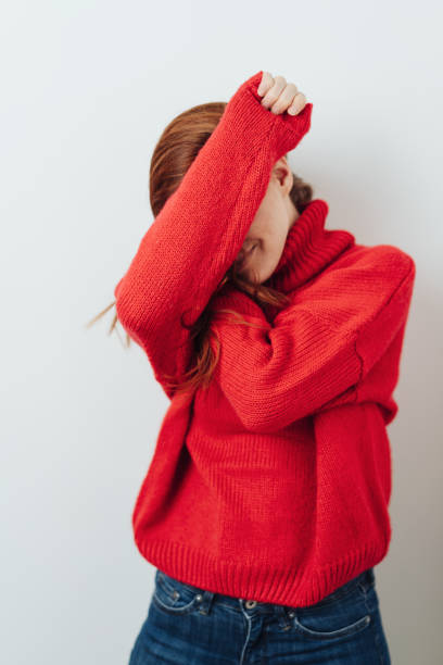 istock Bashful or playful woman hiding behind her arms 1176715155