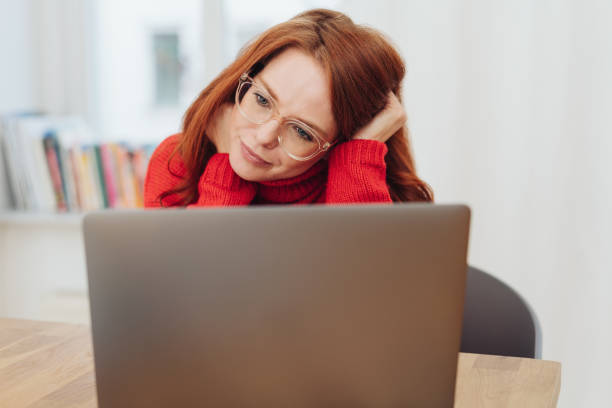 istock Young woman reading on her laptop computer 1176715712