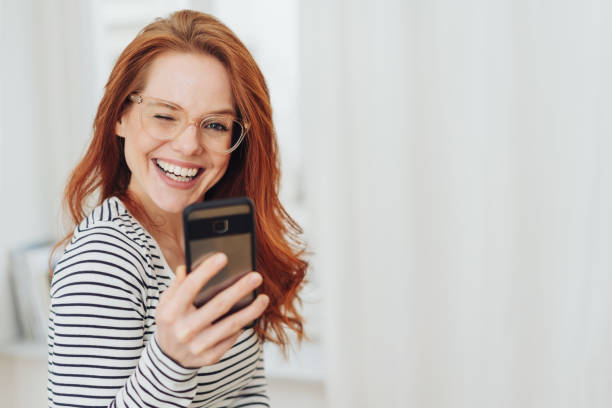 istock Cute playful young redhead woman winking 1176715817