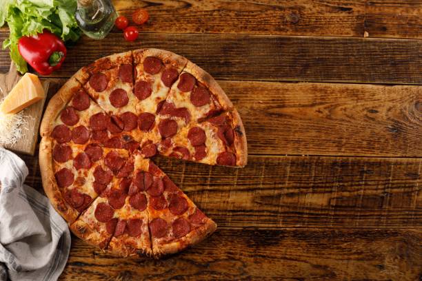 istock Pepperoni pizza on a wooden table. Still life with ingredients. Top view. Copy space. 1176715853