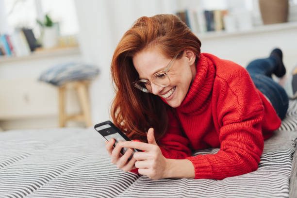 istock Amused young woman laughing at a text message 1176715920