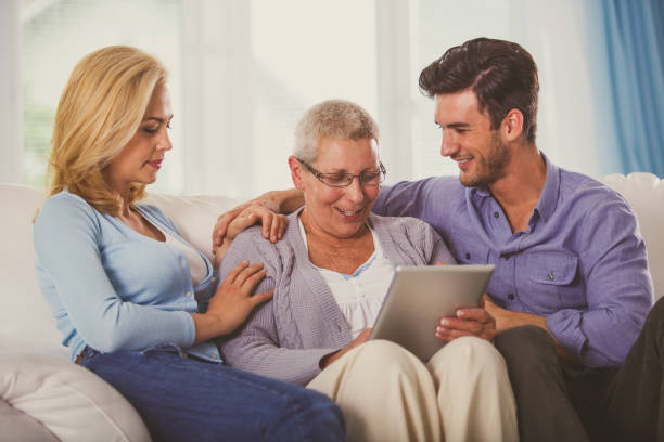 istock Son and daughter teaching their senior mother how to use digital tablet 1176716084