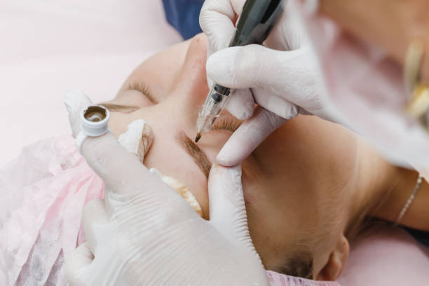 istock Permanent makeup, tattooing of eyebrows. Cosmetologist applying make up 1176716234