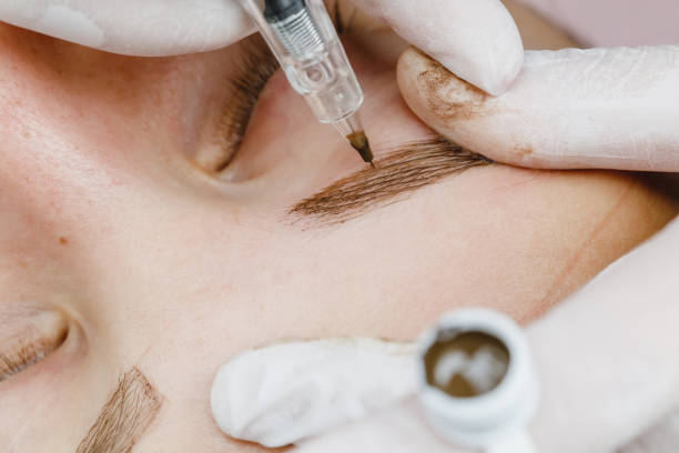 istock Permanent makeup, tattooing of eyebrows. Cosmetologist applying make up 1176716260