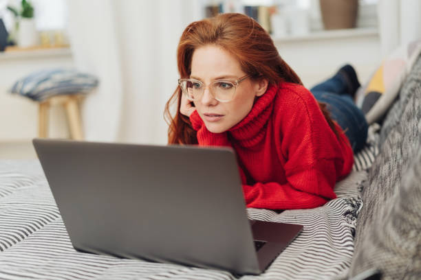 istock Young woman using a laptop on a sofa 1176716459