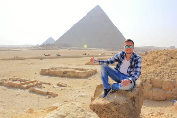 istock Man sitting on the stone with Egypt pyramids view 1176718424