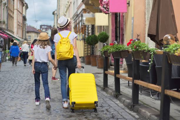 istock Two girls walking in city with suitcase, back view 1176720029
